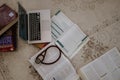 Medical student textbooks with laptop and stethoscope on room carpet