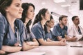 Medical students listening sitting at desk