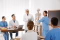 Medical students and professor studying human skeleton anatomy Royalty Free Stock Photo