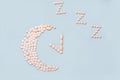 Medical supplement in the evening. Concept Insomnia, sleep problems. Pills in shape of the moon and alarm clock