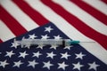 Medical syringe and American flag reflect public health plans