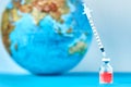 Medical syringe and ampoule with a medicine against Earth globe. Ã¯Â¿Â½oncept of epidemic, virus and human infection