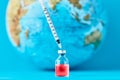 Medical syringe and ampoule with a medicine against Earth globe. Ã¯Â¿Â½oncept of epidemic, virus and human infection