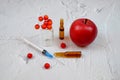 Medical syringe, ampules, red apple and berry