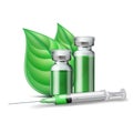 Medical syringe with green liquid and medicine ampoules and vials with green leaves.