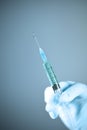 Medical syringe in hand with white glove Royalty Free Stock Photo