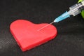 Medical Syringe and a Heart. Heart shaped object and a Cure.