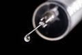 Medical syringe, injection with focus on the needle, falling drop, dripping liquid, macro photography, spot focus. Concept of cure Royalty Free Stock Photo