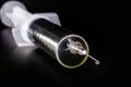 Medical syringe, injection with focus on the needle, falling drop, dripping liquid, macro photography, spot focus. Concept of cure Royalty Free Stock Photo