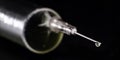Medical syringe, injection with focus on the needle, falling drop, dripping liquid, macro photography, spot focus. Injectable drug Royalty Free Stock Photo