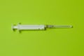 Medical syringe isolated on a green background