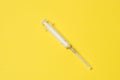 Medical syringe isolated on a yellow background