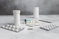 Medical syringe, medicine pills, capsules, vials, on grey concrete background Royalty Free Stock Photo