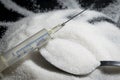 Medical syringe, pile of sugar grain in table spon, concept of d