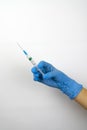 Medical syringe with a vaccine in a hand in a blue glove. Royalty Free Stock Photo
