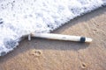 Medical syringe waste and foaming wave on the beach