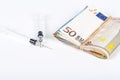 Medical syringes on wad of several euro banknotes bills Royalty Free Stock Photo