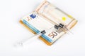 Medical syringes on wad of several euro banknotes bills Royalty Free Stock Photo