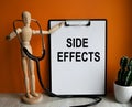 Medical table with a wooden person along with a stethoscope. Inscription SIDE EFFECTS on the clipboard with the holder. Health