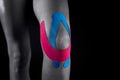 Medical taping for knee stabilization isolated on black background. Royalty Free Stock Photo