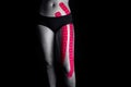 Medical taping for leg pain relief showed on young model.