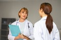 Medical team discussing about case over digital tablet in corridor at hospital Royalty Free Stock Photo