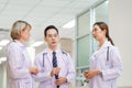 Medical team discussing in the corridor at hospital, team of mixed-races doctors, Group of multi ethnic medics, men and women Royalty Free Stock Photo