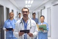 Medical team of doctors looking at camera in corridor at hospital Royalty Free Stock Photo