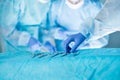 Medical team performing operation. Close up of scrub nurse taking medical instruments for operation with colleagues performing in Royalty Free Stock Photo