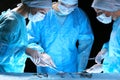 Medical team performing operation. Group of surgeon at work in operating theatre toned in blue Royalty Free Stock Photo