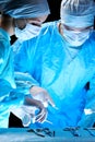 Medical team performing operation. Group of surgeon at work in operating theatre toned in blue Royalty Free Stock Photo