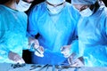 Medical team performing operation. Group of surgeon at work in operating theatre toned in blue Royalty Free Stock Photo