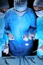 Medical team performing operation. Group of surgeon at work in operating theatre toned in blue Royalty Free Stock Photo