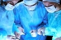 Medical team performing operation. Group of surgeon at work in operating theatre toned in blue Royalty Free Stock Photo