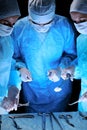 Medical team performing operation. Group of surgeon at work in operating theatre toned in blue Royalty Free Stock Photo