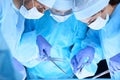 Medical team performing operation. Group of surgeons at work in operating theater toned in blue Royalty Free Stock Photo