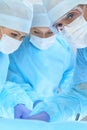 Medical team performing operation. Three of surgeons at work are busy of patient. Medicine, veterinary or healthcare and Royalty Free Stock Photo