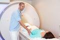 Medical technical assistant preparing scan of knee with MRI