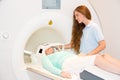 Medical technical assistant preparing scan of patient's head with MRI