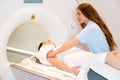 Medical technical assistant preparing scan of shoulder with MRI