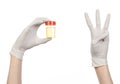 Medical theme: doctor's hand in white gloves holding a transparent container with the analysis of urine on a white background Royalty Free Stock Photo