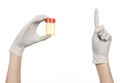 Medical theme: doctor's hand in white gloves holding a transparent container with the analysis of urine on a white background Royalty Free Stock Photo