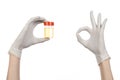 Medical theme: doctor's hand in white gloves holding a transparent container with the analysis of urine on a white background