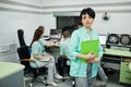 Medical theme .Portrait of female doctor with clipboard against group of doctors meeting in the mri office at diagnostic center in Royalty Free Stock Photo