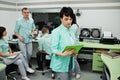 Medical theme .Portrait of female doctor with clipboard against group of doctors meeting in the mri office at diagnostic center in Royalty Free Stock Photo