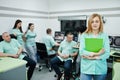 Medical theme .Portrait of female doctor with clipboard against group of doctors meeting in the mri office at diagnostic center in Royalty Free Stock Photo