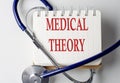 MEDICAL THEORY word on notebook with medical equipment on background