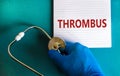 Medical and thrombus symbol. Doctor hand, stethoscope. White note with the word `thrombus`. Beautiful blue background. Doctor ha