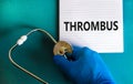 Medical and thrombus symbol. Doctor hand, stethoscope. White note with the word `thrombus`. Beautiful blue background. Doctor ha