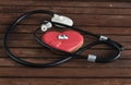 Medical topic. Gingerbread in the shape of a heart with a phonendoscope on a wooden background. Mom`s day. Valentine`s day.